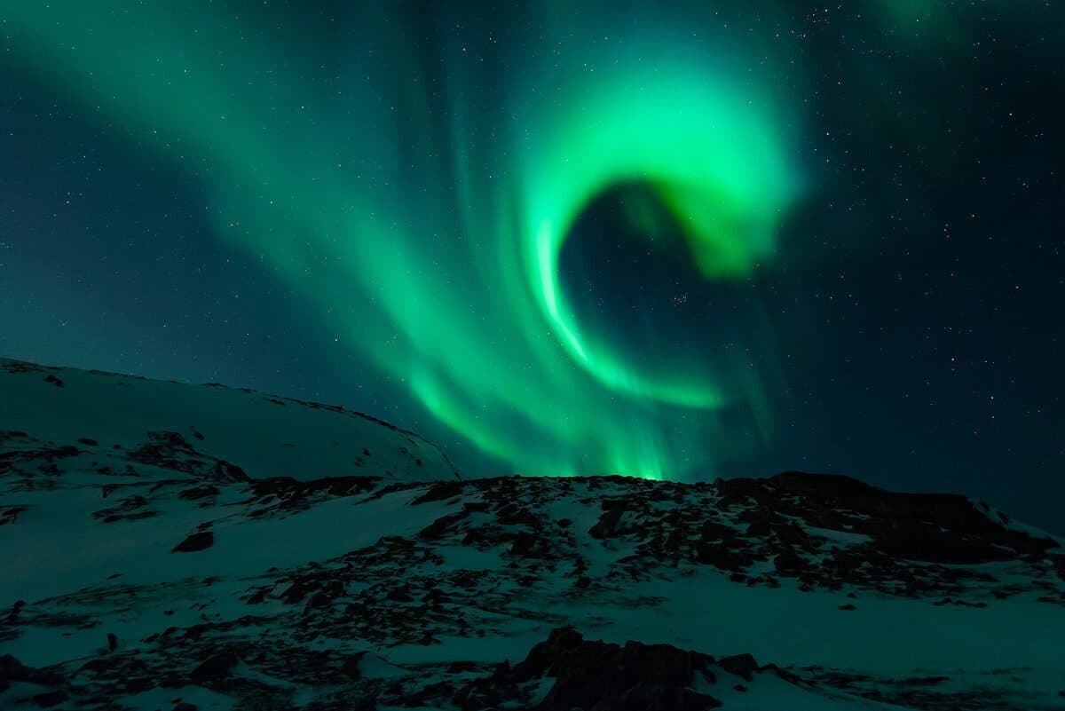foto · aurora boreal verde sobre un paisaje nevado