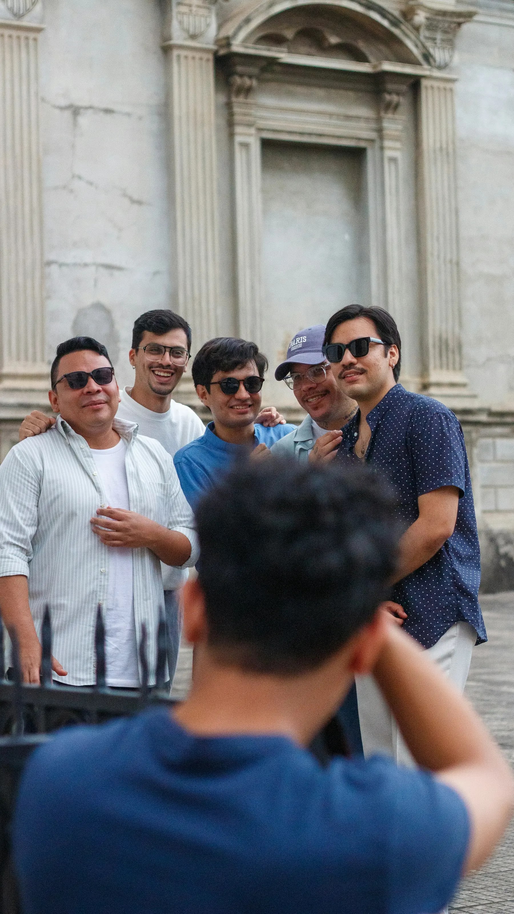 Friends smiling together while sightseeing at a historic landmark