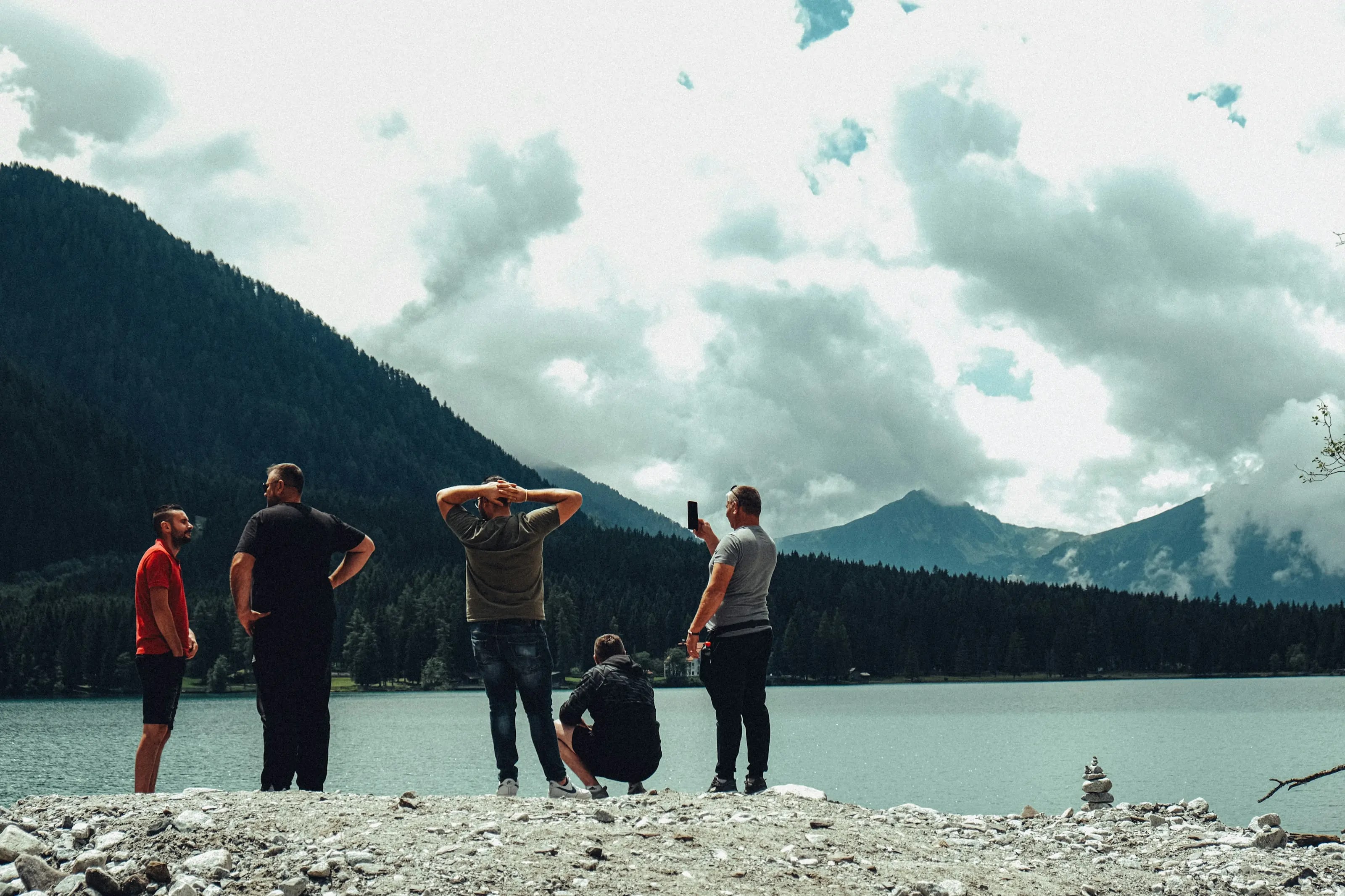 A group of friends taking in a dramatic mountain lake view