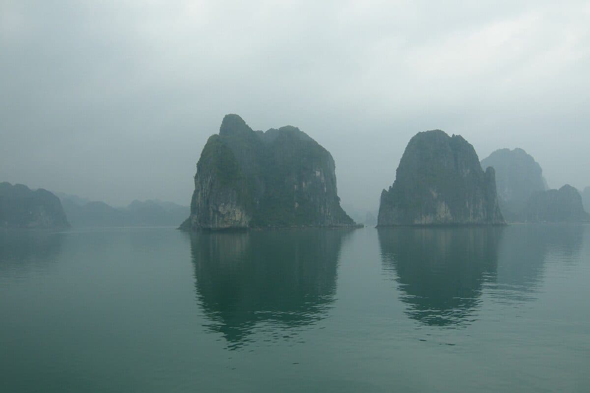 foto · formaciones kársticas emergiendo de la niebla en la bahía de Ha Long